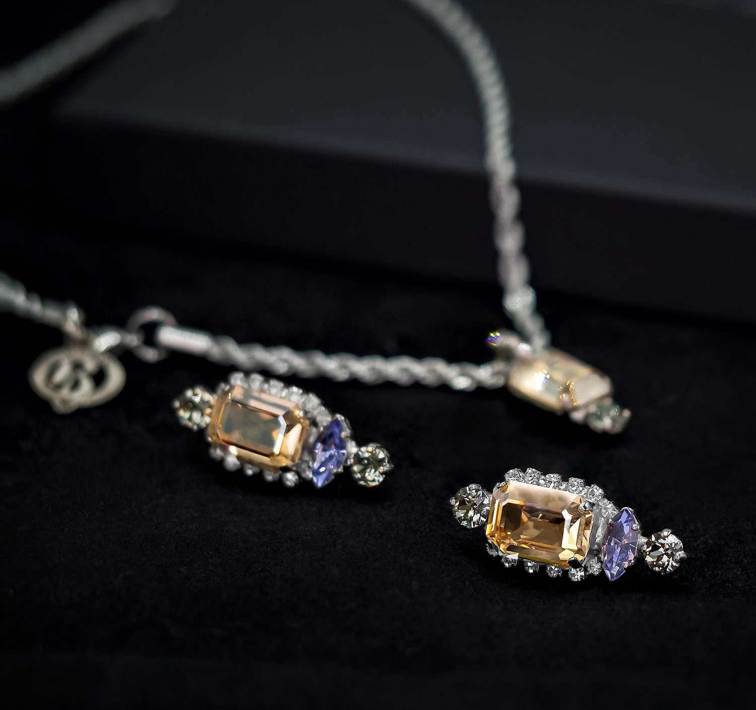 BAROQCO luxurious gift box featuring 'The Gabriella' statement earrings and 'The Raven' necklace. 'The Gabriella' dazzles with Golden Shade, Denim Blue, and Black Diamond Swarovski crystals, while 'The Raven' radiates elegance with Golden Shade, Denim Blue, and Crystal elements. Each piece is expertly crafted with genuine CRYSTAL®, semi-precious stones, and freshwater pearls, set in recycled silver or gold plating—nickel-free. A timeless expression of luxury, haute couture, and regal elegance.